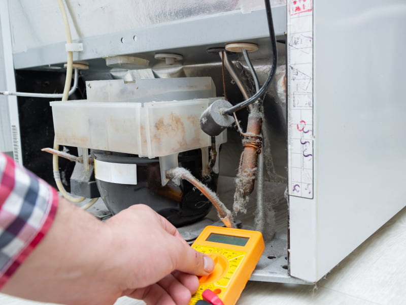 appliance repair contractor testing a refrigerators voltage merlin or